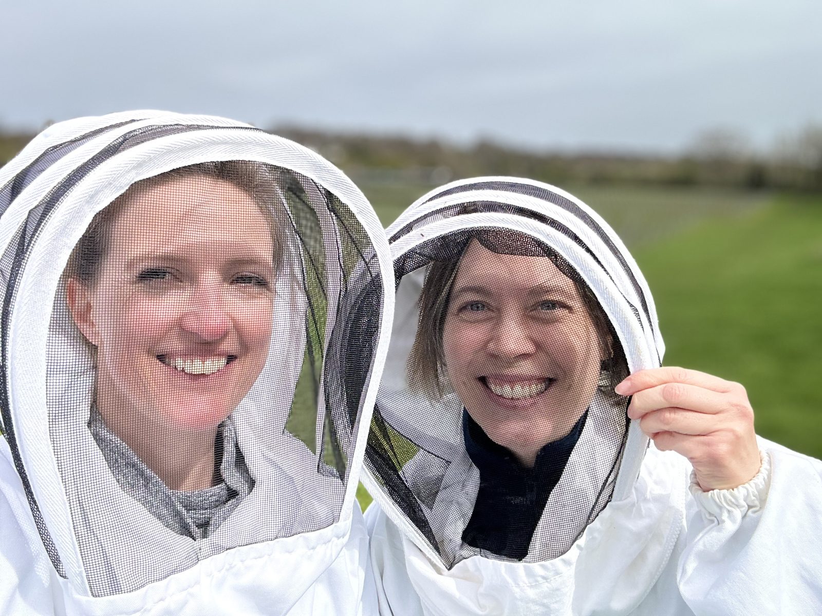 A group gathered round the hive with the beekeeper