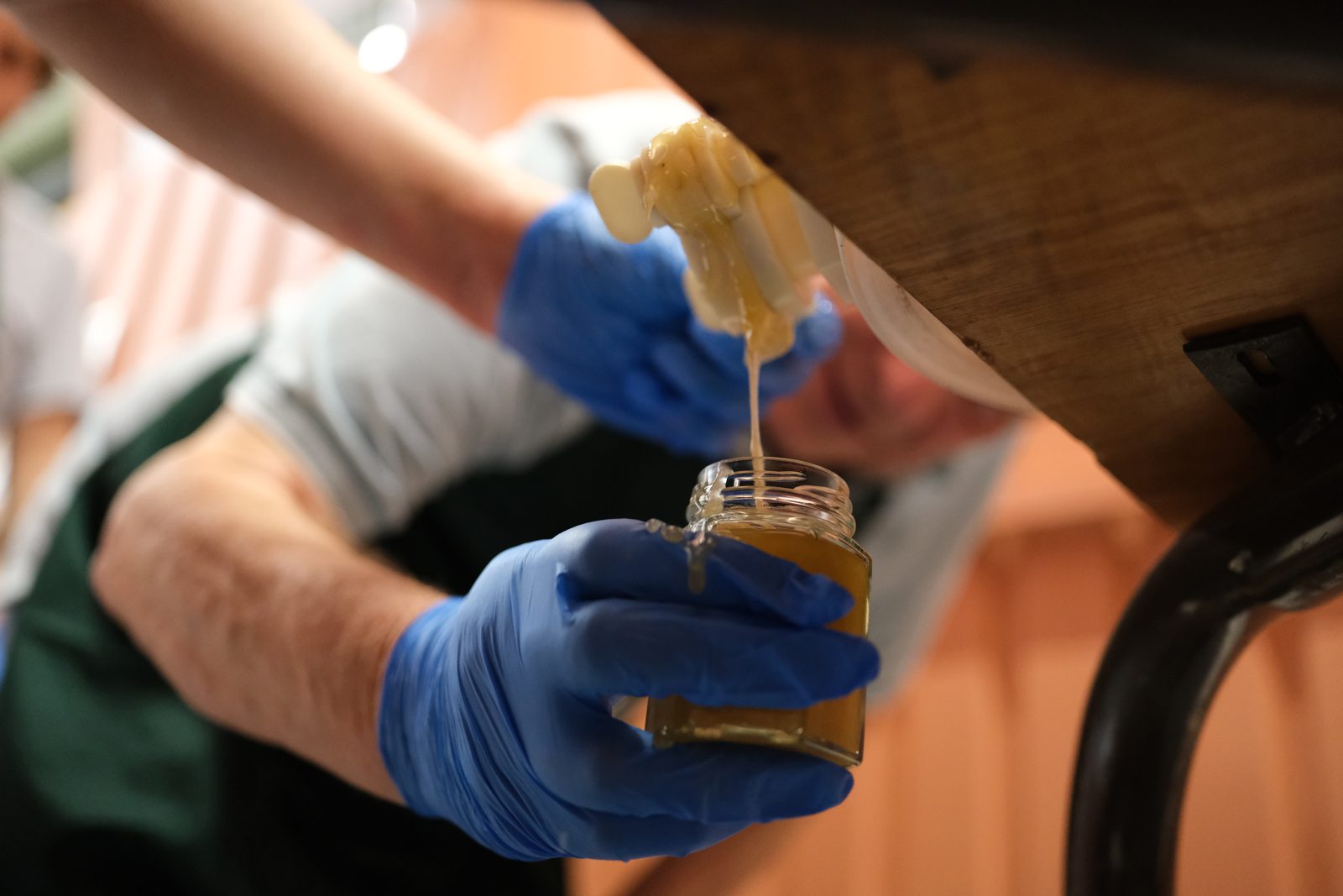 Filling a jar with freshly harvested honey